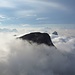 Der der Puezspitze südöstlich vorgelagerte Gipfel, rechts im Hintergrund ragt der Sassongher aus den Wolken