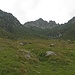 L'ampia conca dell'Alpe d'Aian, mentre a sinistra s'intravvede la Bocchetta di Camedo.