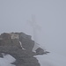 Dann wird im Nebel das Gipfelkreuz des Schareck sichtbar.