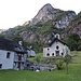 Faèd.  Hinter der Kapelle sieht man das bewaldete Band, auf dem der Weg zuerst von rechts nach links aufsteigt und dann von links nach rechts, um nach Terrasc zu gelangen. 
