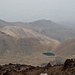 Im Abstieg vom Sabalan - Tiefblick auf die östlich des Vulkans vorgelagerten niedrigeren Berge, zwischen denen sich auch ein kleiner See befindet.