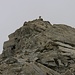 Auf einem Geröllpfad geht es entlang des obersten Ostgrat dem Gipfelsteinmann entgegen.