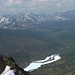 Tiefblick auf das durch frierendes Wasser während des Winters entstandene Eisfeld und die Gipfel der Tombstone Mountains