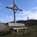 Croce e panchina nei pressi dell'Alp di Plaun.