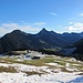 Blick über die sanften Matten der Pfrontner Alpe, dahinter der Aggenstein und weitere Berge der Tannheimer Gruppe.