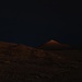 At night, the crater illuminates the surrounding hills
