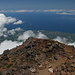 Pico - Auslick vom Pico Piquinho. Größere Wolkenlücken geben den Blick frei auf die Nordküste und den Atlantik, 2.351 m unter uns. Im Hintergrund rechts ist der Westzipfel von São Jorge zu erahnen.