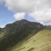 Die Cima Sasso von der Colma die Belmello. Der Aufstieg erfolgt durch die Gras- und Geröllhänge rechts unterhalb des Gipfels.
