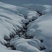 Der Trattenbach schneidet sich in die verschneite Landschaft rein