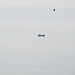 Der einsame Mann und das Meer und ein Höhenzug am Schweizer Ufer im dunstigen Hintergrund