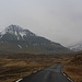 Etwa 120m oberhanb von Eiði erkannte ich erstmals den Slættaratindur (880m). Sein Gipfel liegt leider im Nebel und nur der markante Gradbuckel Hálsur davor ist zu sehen. Vom Vaðhorn (727m) rechts auf dem Bild stecken die obersten Meter ebenfalls im Nebel.<br /><br />Wenige Meter nachdem ich das Foto aufgenommen habe nahm mich ein freundlicher Einwohner von Gjógv mit seinem Auto bis zum eigentlichen Ausgangspunkt Eiðisskarð mit. Ich konnte mir so glücklicherweise einen Marsch entlang der Strasse ersparen und etwa 45 Minuten gewinnen.