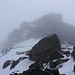 Wenig unterhalb des Gipfels erreichte ich schliesslich den obersten Westgrat. Die Felsen im Nebel sind schon die obersten Meter hinauf zum Gipfelplateau.