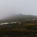 Ørvisfelli: Blick von der Ostgratschulter auf dem Grat in Richtung Gipfel. Im Nebel ist lediglich der erste von drei Felsstufen zu sehen. Von dieser Stelle sind es noch zirka 150 Höhenmeter bis zum Gipfel.