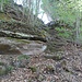 Rechter Hand führen ein paar alte Stufen im Sandstein in eine Lücke im Schlossbergmassiv hinauf.