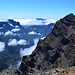 Am Kraterrand der Caldera de Taburiente, mit Blick nach Süden. Hinter der wolkenüberströmten Cumbre Nueva sind dei Vulkane der Cumbre Vieja zu sehen. 