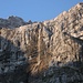 Die Eiskarlen befinden sich oberhalb der etwa 400m hohen Felswand; ein Wasserfall kündet vom großen Höhenunterschied.