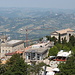 San Marino - Ausblick von der Festung Guaita (aka La prima torre/Erster Turm bzw. Rocca). Vorbei am Palazzo Pubblico (links) schaut man ins hügelige Umland.