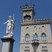 San Marino - Vorbei an der Statua della Libertà (Freitheitsstatue) geht der Blick zum Palazzo Pubblico, welcher als Sitz der Regierenden Kapitäne, des Großen und Allgemeinen Rates und der Regierung der Republik dient. Am Gebäude ist auch die san-marinesische Staatsflagge zu erkennen. 