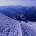 Im Aufstieg zum Elbrus - Während wir durch die Südflanke der östlichen Bergkuppe stapfen, bilden die höchsten Berge Georgiens die Kulisse: Das mächtige Shkhara-Massiv (5.201 m, mittig) und die Spitze des Dykhtau (5.205 m, links daneben) sind im Bildhintergrund zu erkennen.