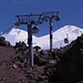 Bei Staryj Krugozor  - Zwei quasi parallele Kabinenbahnen führen derzeit von Azau (ca. 2.350 m) über die Zwischenstation Staryj Krugozor (2.937 m) zur Station Mir (3.469 m). Dort kann in einen Sessellift umgestiegen werden, der weiter nach Garabashi (3.703 m) fährt. Im Bild gondelt die neuere der beiden Bahnen durch die Vulkanlandschaft südlich der beiden Elbrus-Gipfel. Foto vom 17.07.2015.