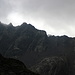 Im Aufstieg zwischen La Molinassa und Refugi de Baiau - Für wenige Sekunden verziehen sich die Wolken, und wir können das einzige Mal während unserer heutigen Tour den Comapedrosa aus der Ferne sehen. Genau dort, wo der Gipfel über den Grenzkamm lugt, werden wir diesen später überqueren.