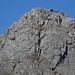 The upper part of the Höch Windgällen ascent, with three hikers just below the two chimneys that constitute the crux of the route.