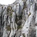 Der Weiterweg führt dem gerade noch sichtbaren Drahtseil entlang durch die Felsen nach links oben.