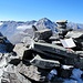 Gipfelsteinmann und -buch, dahinter in der Ferne die Walliser Viertausender