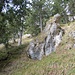 Steil den Wiesenhang hinauf an einigen Felsen vorbei