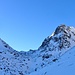 Blick zurück zur Capanna Christallina. Rechts unterhalb der grossen Felswand geht der "Weg" quer durch das verschneite Band. 