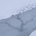 Wie Adern durchziehen Wasserläufe das dünne Eis am Rand des Stausees Isel