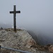 Kreuz auf dem Pizalun-Gipfel, dahinter einfach nur Nebel