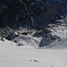 Tiefblick von der etwa 2900m hohen Scharte zwischen Patteriol Vorgipfel und Horn über die Aufstiegsroute mit dem verschneiten Hochkarfeld. Unten ist das kleine Plateau auf 2500m zu sehen, ganz Unten das Fasultal.