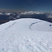 Hvannadalshnúkur - Ausblick am Gipfel. In etwa südwestliche/westliche Richtung geht der Blick über den gletscherbedeckten Gratrücken, der vom höchsten Berg Islands talwärts zieht. Links ist der Sander Skeiðarársandur zu erahnen, rechts die Gletscherzunge Skeiðarárjökull.