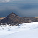 Im Abstieg vom Snæfellsjökull - Ausblick in etwa 1.000 m zum Stapafell. Die kleinen Orte Hellnar und Anarstapi (links) sind an der Küste zu erahnen. Und auch die Piste F570 ist zu erkennen. Dort befindet sich der Ausgangs- und Endpunkt unserer heutigen Tour, an der Schneegrenze in etwa 340 m Höhe. Bis dahin ist aber noch ein ganzes Stück Weg im zunehmend weichen Schnee zurückzulegen...