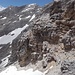 Blick aus der Scharte Richtung Südgrat der Kaltwasserkarspitze. Um zum Grauen Kamin zu kommen, überquert man das Schneefeld im Vordergrund und quert an den Felsen leicht absteigend nach links (Westen)