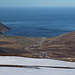 Im Abstieg vom Geldingafjall - Tiefblick hinunter zur Bucht Njarðvík, wo einige Höfe zu erkennen sind. Gut ist auch die Straße 94 auszumachen, die um die ins Meer abfallenden Bergflanken weiter nach Bakkagerði am Borgarfjörður eystri führt (rechts).