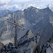 Das schöne kleine Gipfelkreuz des Puitkogels, im Hintergrund die Hohe Geige mit dem markanten Westgrat.
