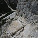 Steilabstieg ins Val Travenanzes - zertrümmerte Holzbohlen und Seilversicherungen sprechen eine deutliche Sprache: hier gibt es gelegentlich Steinschlag..