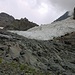 Während man über die Gletscherschliffplatten aufsteigt, erkennt man nach etwa 150m Aufstieg den linken Teil des Gletschers. Beide Teile des Ледник Домбайский (Lednik Dombajskij) sind durch einen Fels voneinander getrennt. Wichtig ist, dass man weiter nach links oben geht um den linken Gletscherteil anzusteuern.