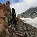 Bei einem Felsturm wird der linke, nördliche Teilgletscher verlassen. Unter einem befindet sich der rechte, grössere Arm des Ледник Домбайский (Lednik Dombajskij). Der weitere Aufstieg erfolgt über die Geröllhänge parallel zum rechten Gletscherteil.