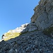 Nach der gesicherten Schlüsselstelle steigt man auf dem Geröllfeld hinauf und stösst der Wegspur folgend bald auf die Schwachstelle in den Felsen (links im Bild, von der Sonne beschienen).