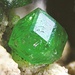 <b>Grossularia cromifera Ca3Al2(SiO4)3. Dimensione: 1 mm.<br />È un granato verde di particolare lucentezza, trovato da Fabio Girlanda in rocce ultrabasiche di color rosso-bruno, nelle Centovalli.<br />Foto di Mischa Crumbach.<br />Un esame analitico dettagliato eseguito all'ETH di Zurigo con una microsonda elettronica ha rilevato la presenza di cromo, ferro, manganese e titanio.</b>
