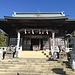Der Tozan-Schrein, flankiert von Wächterfiguren und Laternen. Das Tau resp. Götterseil (shimenawa) über dem Eingang markiert im shintoistischen Glauben den Bereich der Götter.