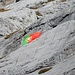 abseits des Weges hängt eine grössere Fahne (Portugal) in den Felsen