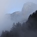 Ein Felspfeiler der Alp Sigel taucht durch den Nebel auf.