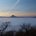 Lovoš - Ausblick zur etwa nordwestlich gelegenen Milešovka und zur benachbarten  Kletečná. Der dazwischen liegende Sattel Paškapole (442 m) befindet sich geradeso im Nebel.