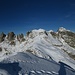 ..... stehe ich auf dem höchsten Punkt des Cimon Rava. Nun ja, ein Sechstausender ist es wohl nicht so ganz - aber immerhin, die Landschaft im Winterkleid macht ganz nett etwas her.<br />Der Blick geht nach Norden zur benachbarten Cima Trento (mittig, 2496m, sie dürfte wohl ebenfalls ersteigbar sein) zur Cima Quarazza (rechts, 2530m); die Felstürme linksseitig gehören zur Cima Caldenave (2442m).