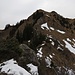Südabstieg vom Hochrohkopf, unterhalb des Gipfels der schmale Felsabschnitt, darunter das Schneefeld, das auf der Grasband-Umgehung beginnt.