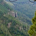 Aussicht im Abstieg in bewaldetes Gelände mit skurrilen Felsen.